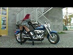 Red haired biker babe is posing on her boyfriend's bike and slowly getting naked