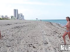 Two babes are playing with each others pussy on the beach as well as with their friend